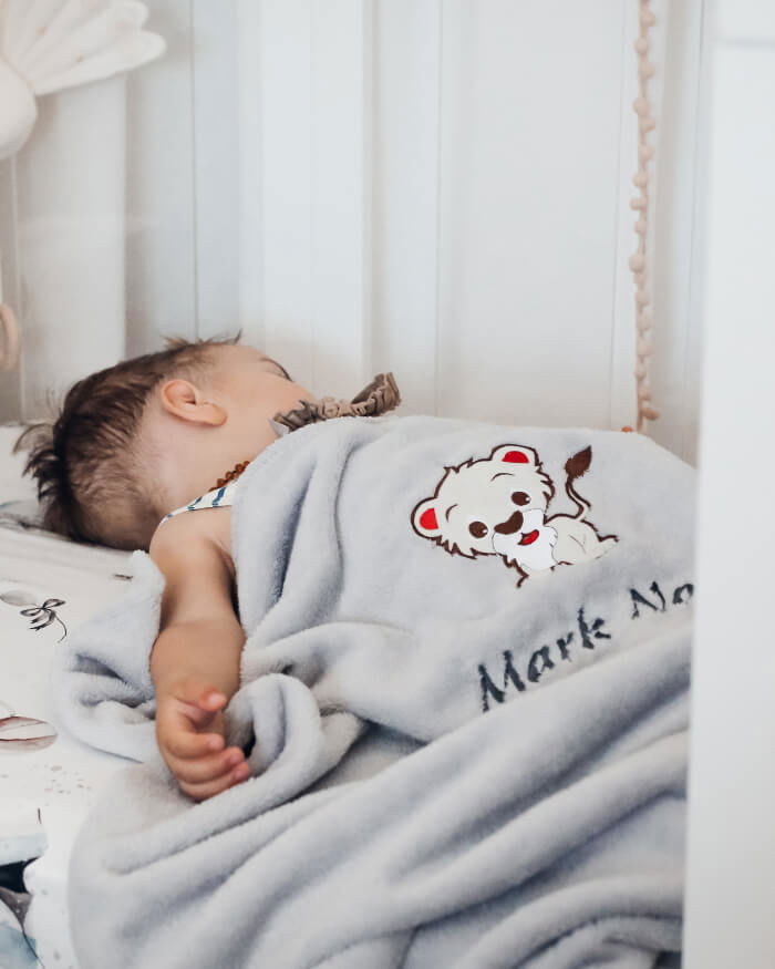 Boy Mark Noa sleeping covered with his personalized blanket