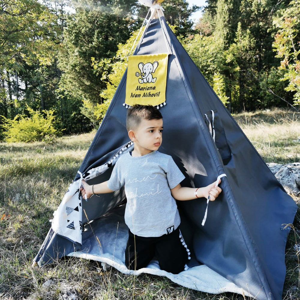 Boy kid enjoying his personalized teepee tent and playing in it