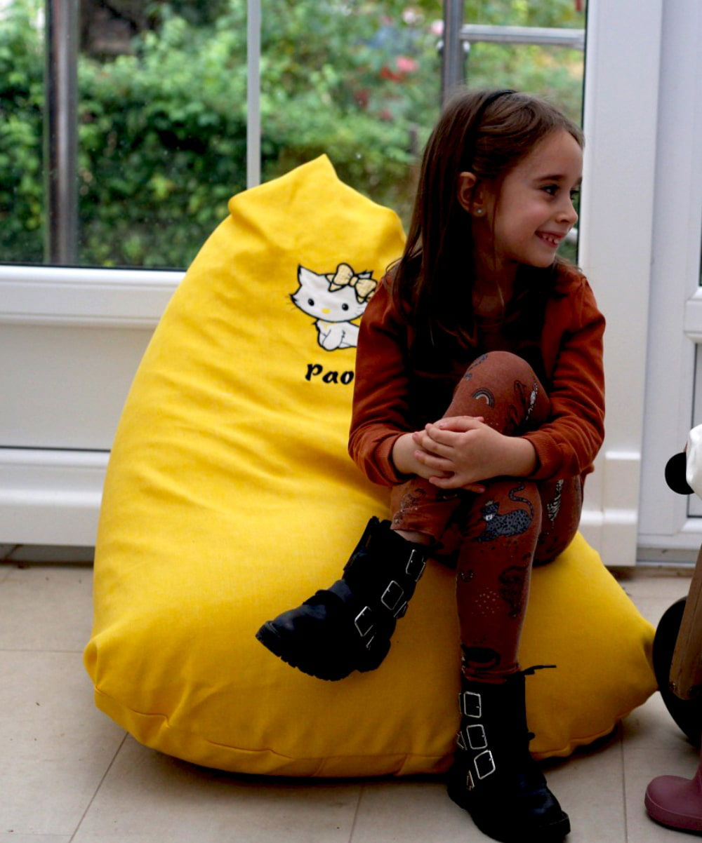 Little girl sitting in a personalized bean bag and enjoying it